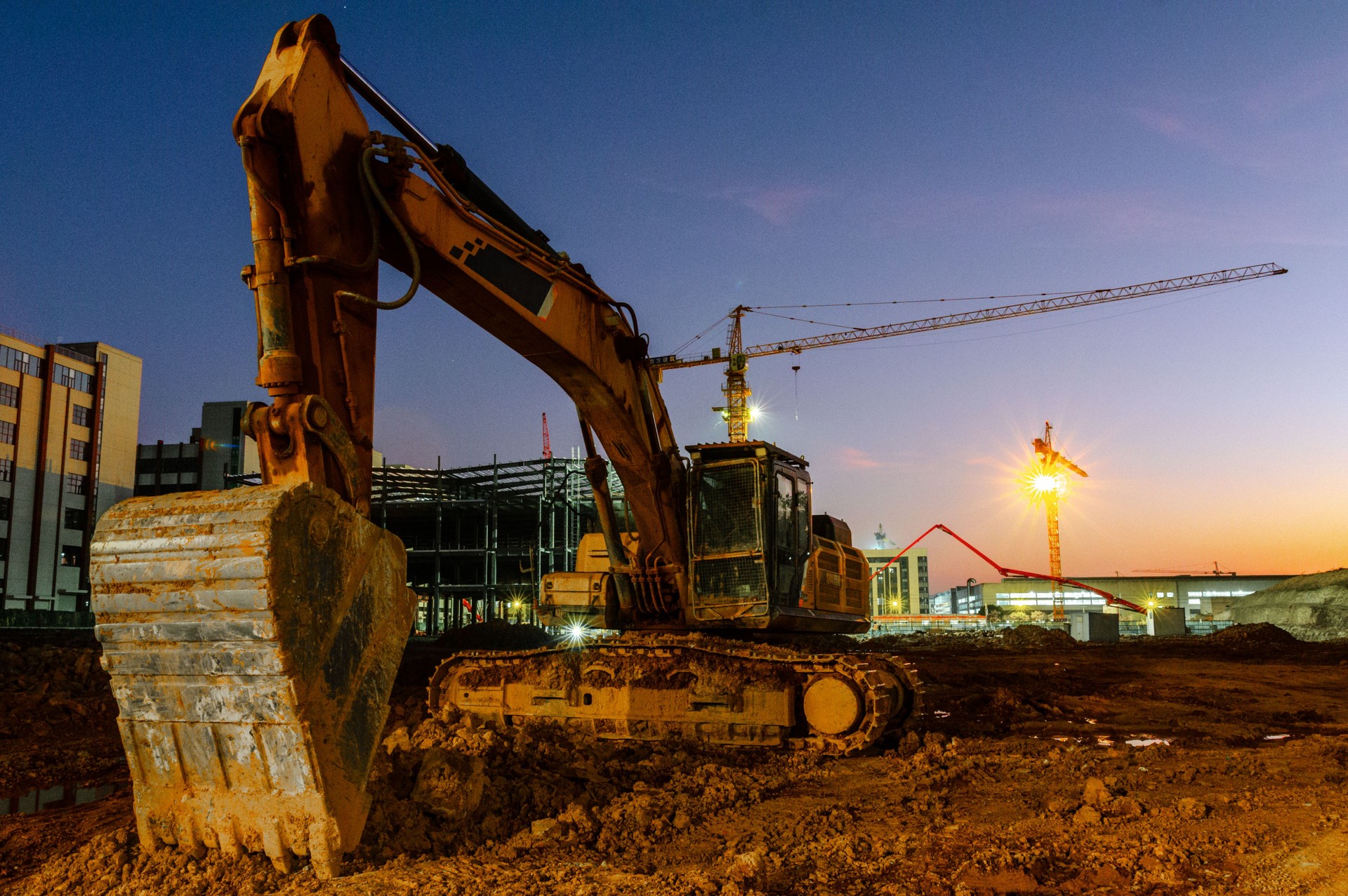 Construction sites at dusk, excavators, cranes,